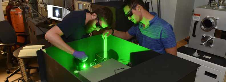 Researchers work with green laser in the lab