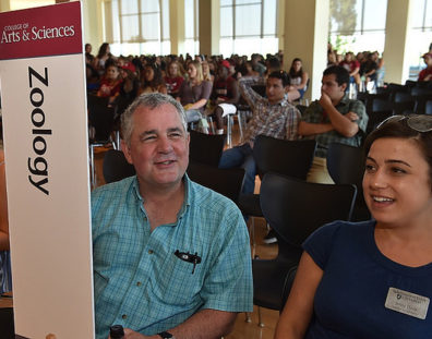 faculty with sign and students