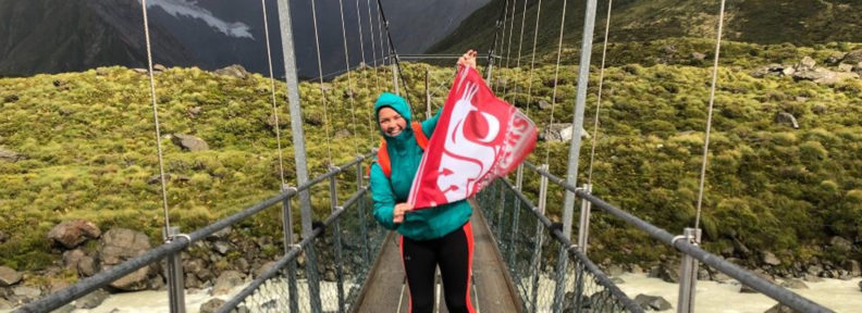 student on bridge with WSU flag