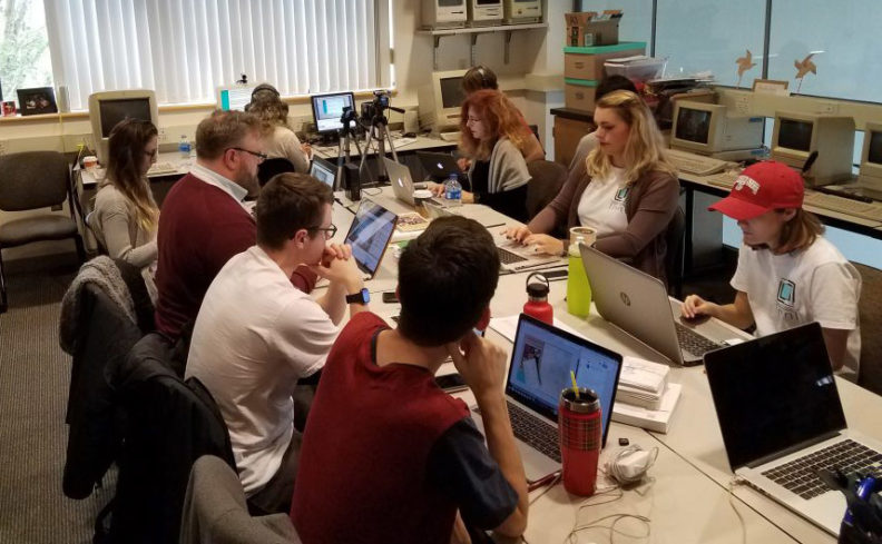 people at table with laptops