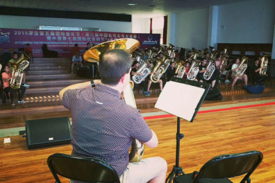 Chris Dickey performs with his tuba in front of an audience of tuba students.