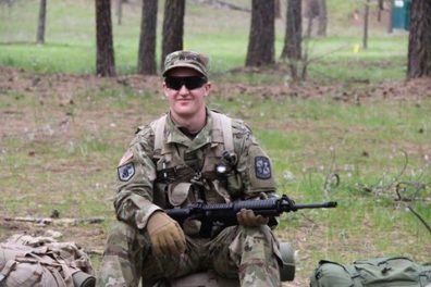 Gigerich in military fatigues and service rifle.