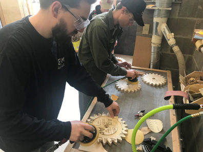 Students working on wooden cogs.