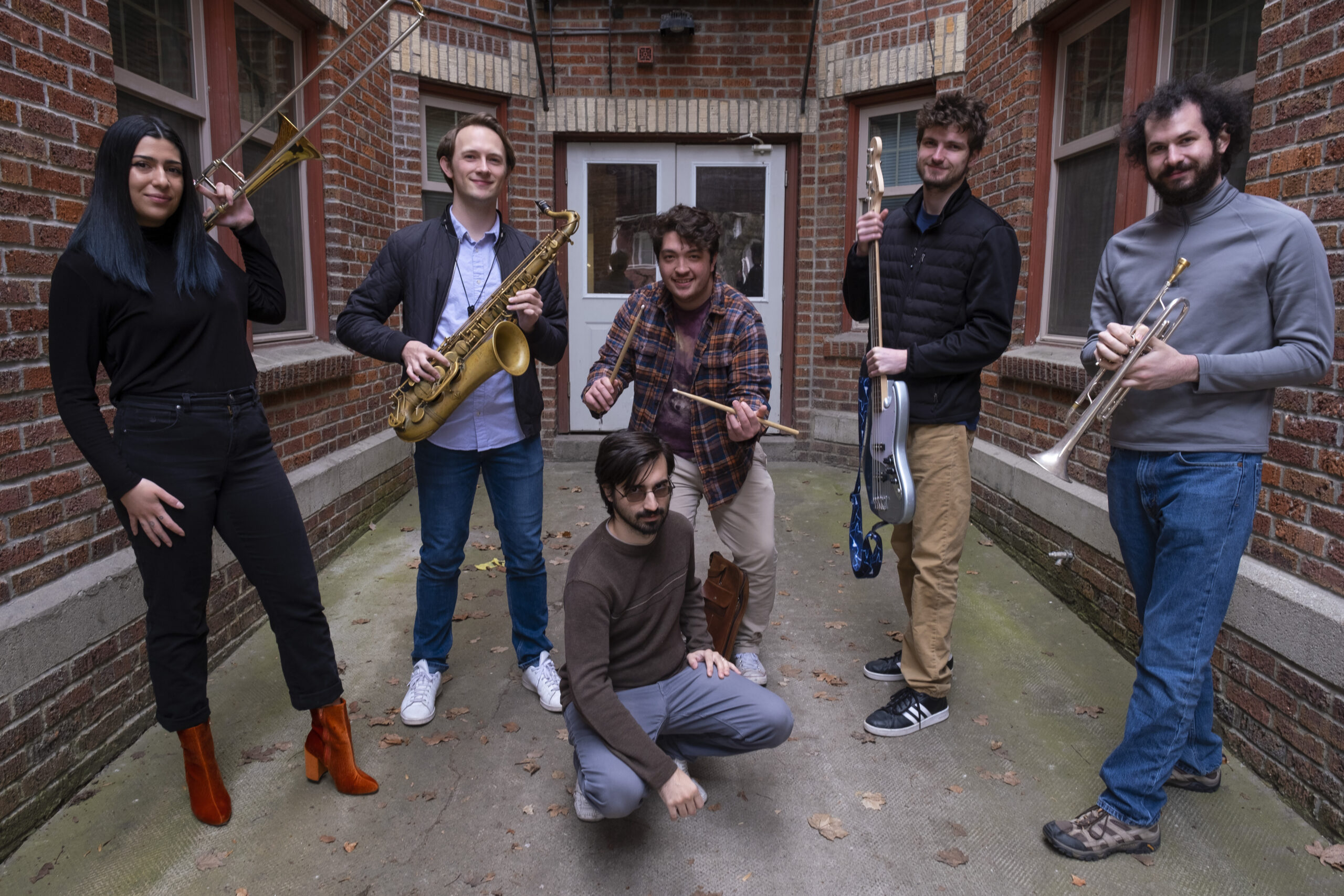 Musicians pose in an alley.