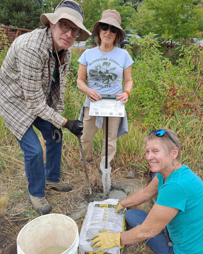 A group installing a sign in the grass.