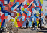 Students and faculty painting a mural.
