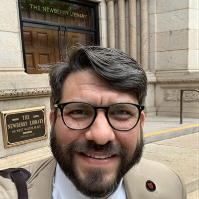Man outside a stone building.