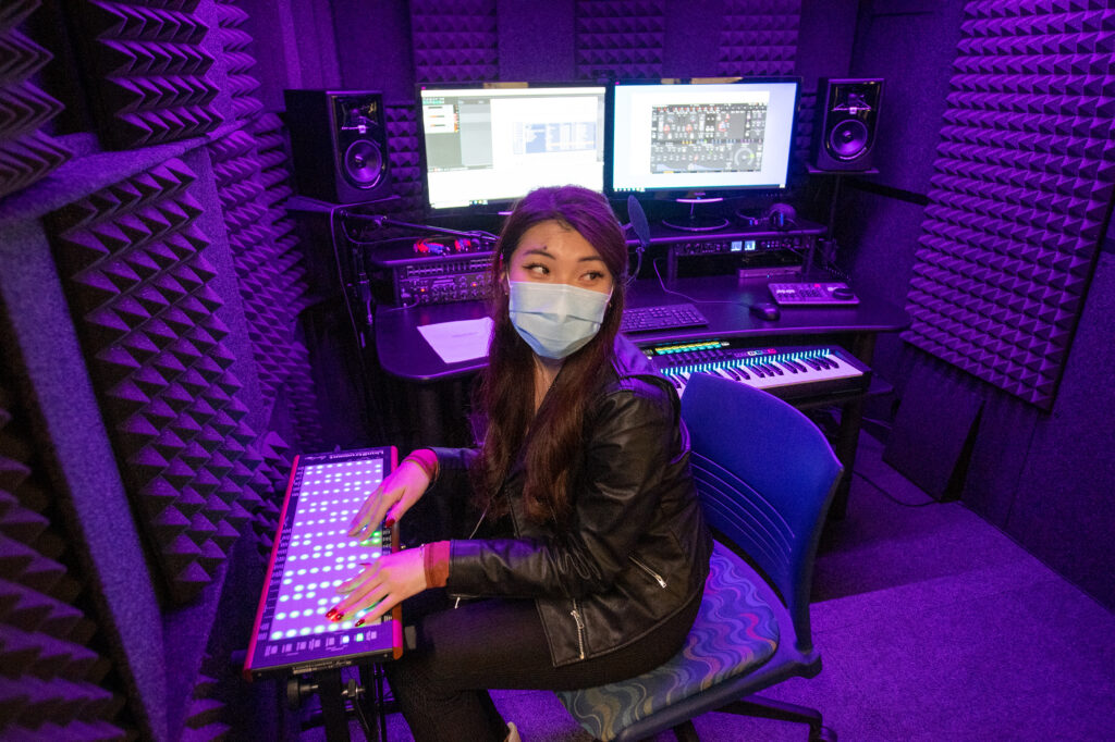 Student posing in the Audiolab.