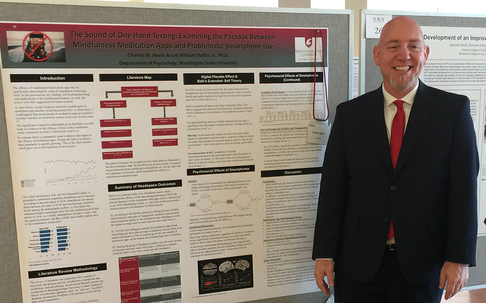 Photo: Charles Nevin, SURCA winner, poses in front of his research poster.