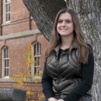 Samantha McNicholas sitting by a tree.