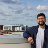 Rodriguez leans against the railing of the PACCAR building on the roof
