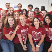 Voiland College ambassadors wearing crimson t-shirts pose in four rows for a group picture.