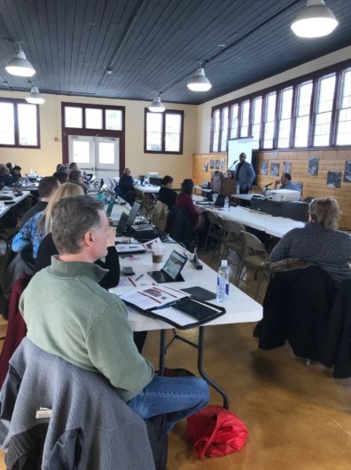 People listen to a presenter during a workshop