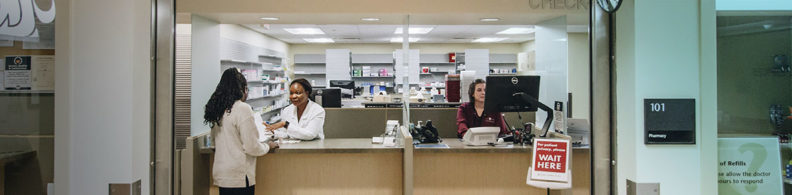 Student discussion a prescription with an HWS pharmacy technician.
