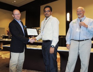 Thomas Bass, left, livestock environment specialist at Montana State University and chair of the judging panel, and Mark Risse, right, congratulate WSU student George Neerackal on his poster win at Waste to Worth. (Courtesy photo)