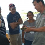Research winemaker, Richard Larsen (right) and enology certificate students look at grape clusters during Fall 2016 wine camp