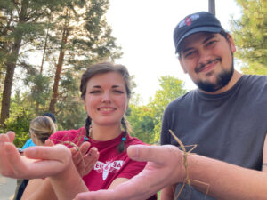 Two entomology students holding stick bugs