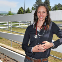 Haley Primley standing near a fence outside the veterinary teaching hospital