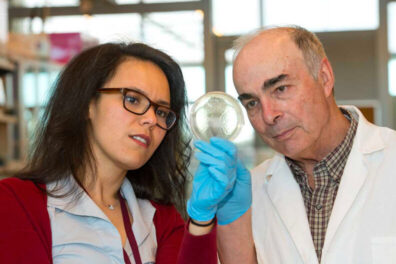 Dr. Kawas and Harding are looking at as slide in a lab
