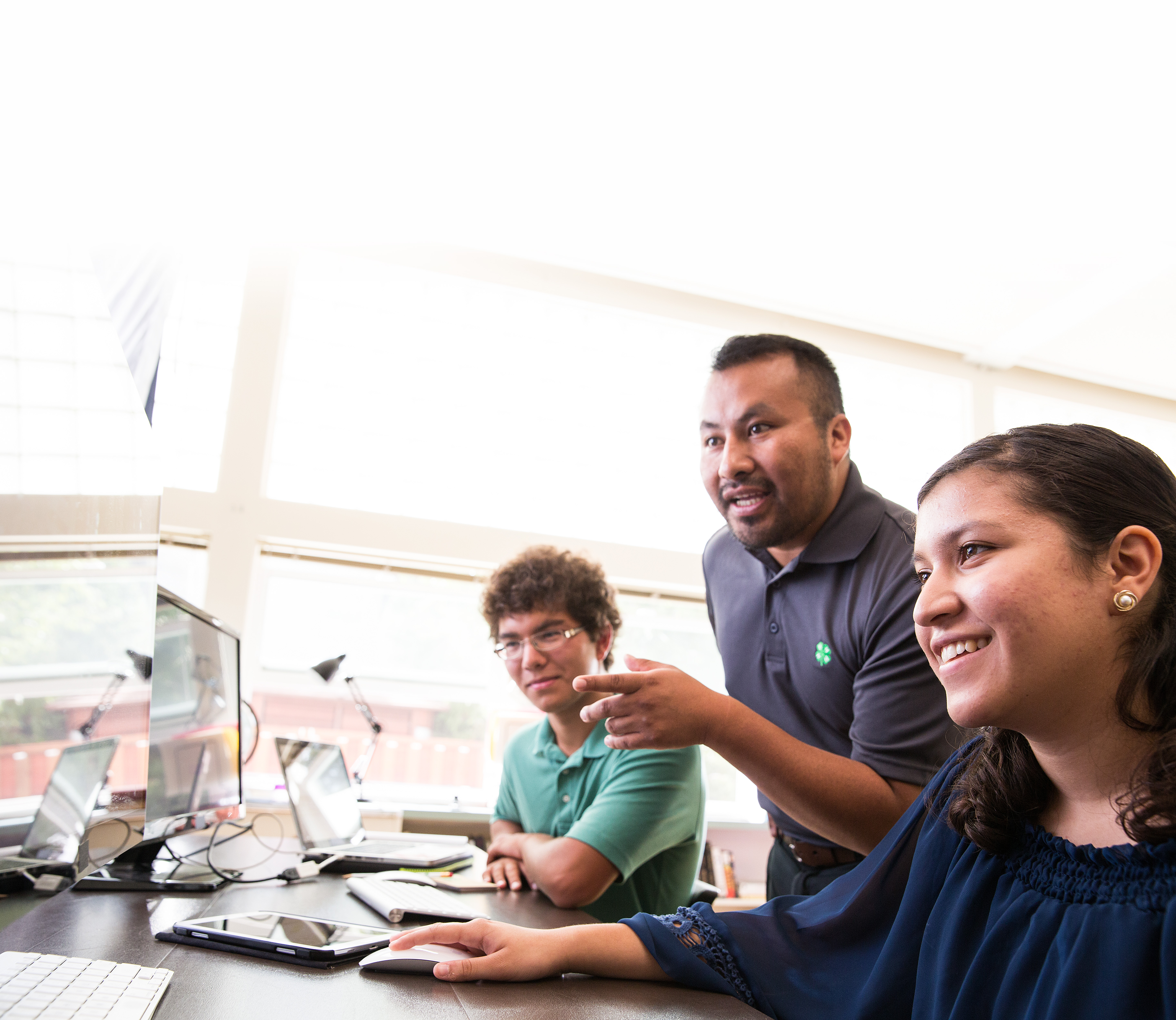 4-H leader helping youth on the computer.
