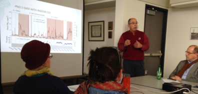 Faculty in an office viewing a PowerPoint presentation. 