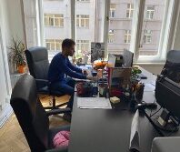 man sitting behind a desk looking at a computer screen