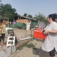 woman holding a red bin with food outside