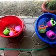 toy plastic sprinkling cans in bowl of water