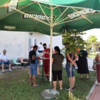 people standing outside under a sun umbrella