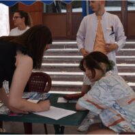 young woman bending over table checking in another person