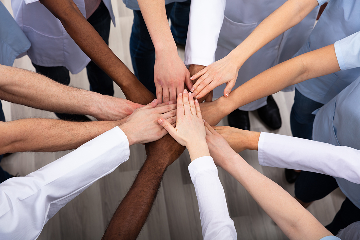 Group of people stacking hands in a circle.