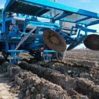 A picture of adjustable hilling discs on a small plot potato planter.