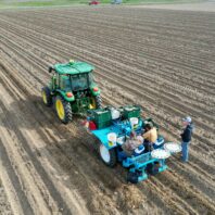 A picture of a small plot potato planter in the field.