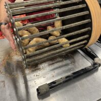 A picture of a small potato bruise barrel with potatoes inside.