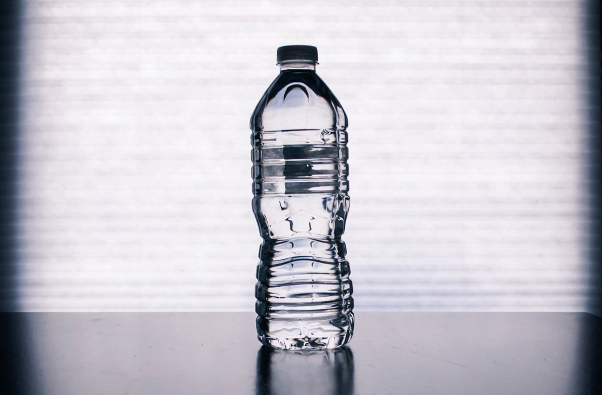 Plastic bottle of water on countertop.