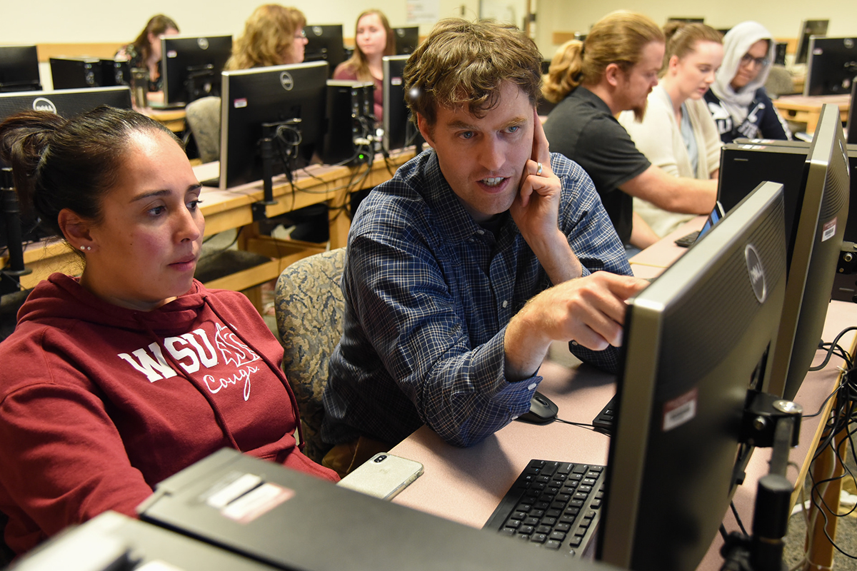large computer education room with students and instructors