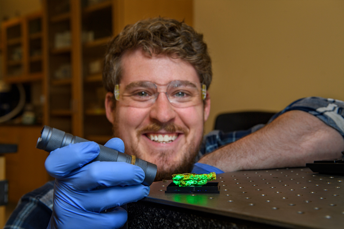 A researcher shines a light on a mineral sample.