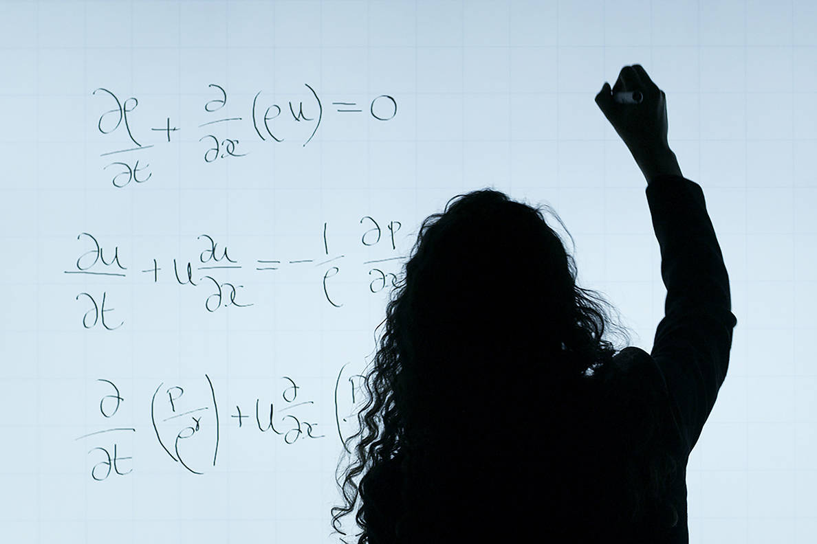 Female engineer writing equations.