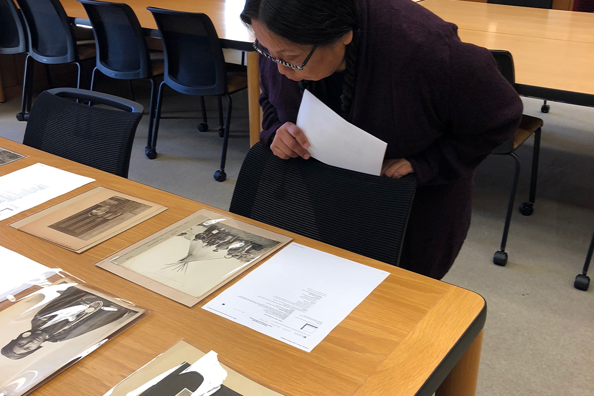 Valerie Switzler views photographs on a table.