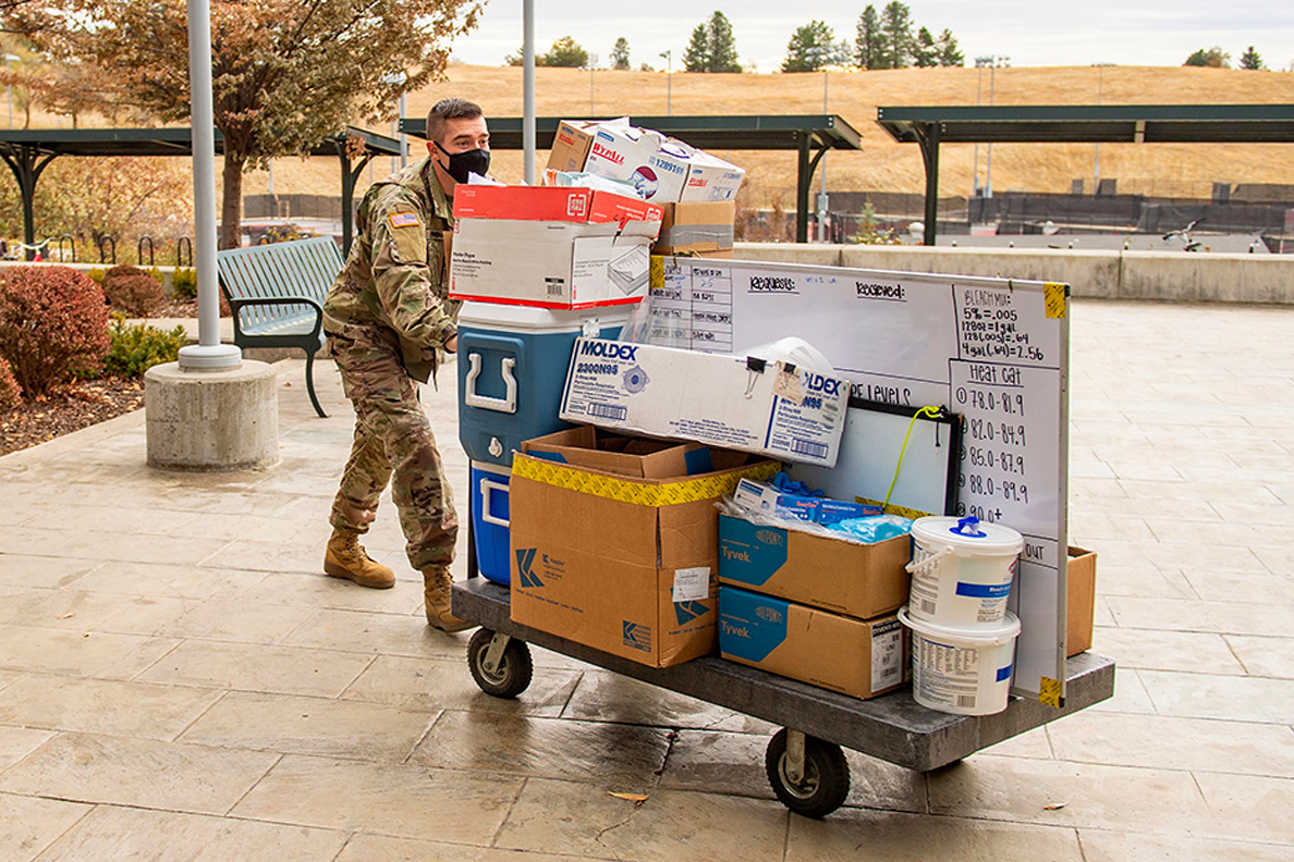 National Guardsman pushing a supply cart.