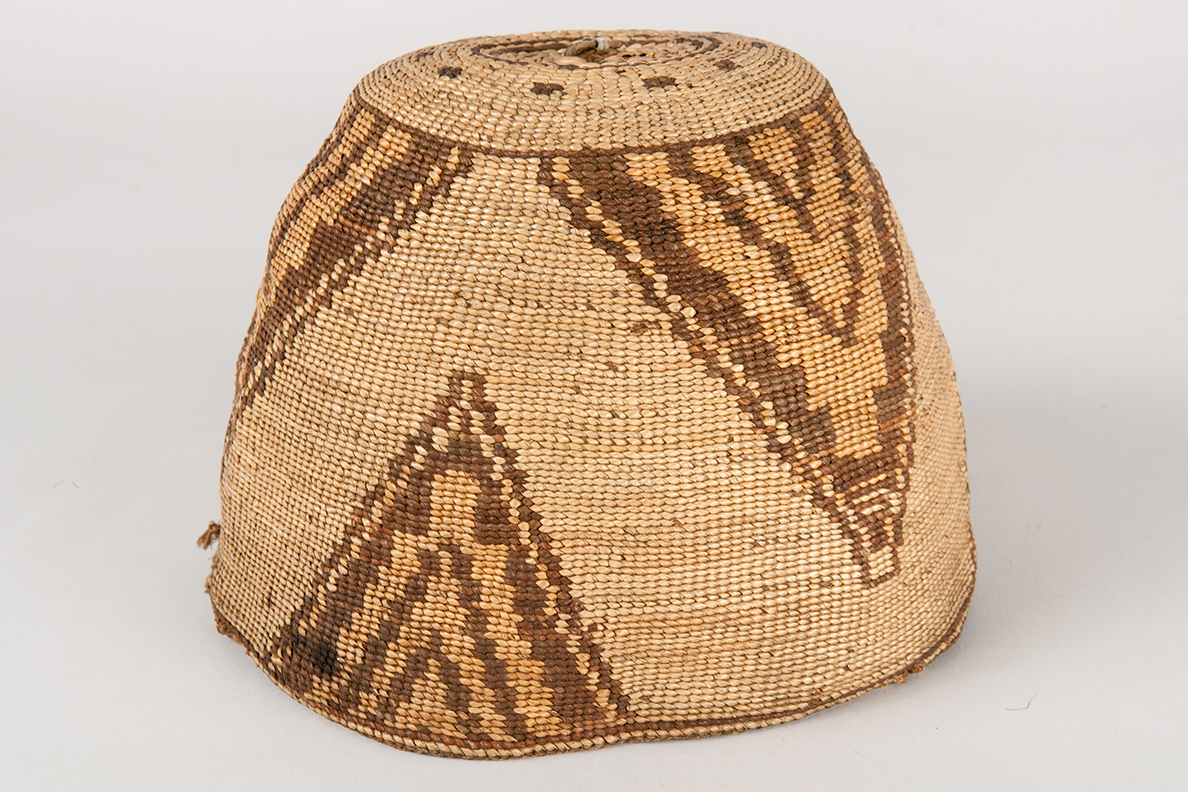 Closeup of a Nez Perce basket hat displayed against a white background.