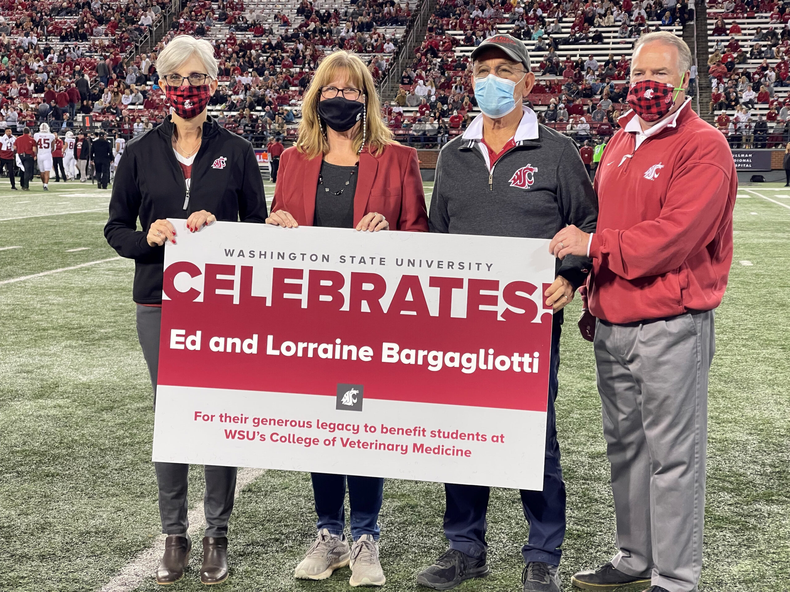 Members of the College of Veterinary Medicine accept an estate gift at a football game.