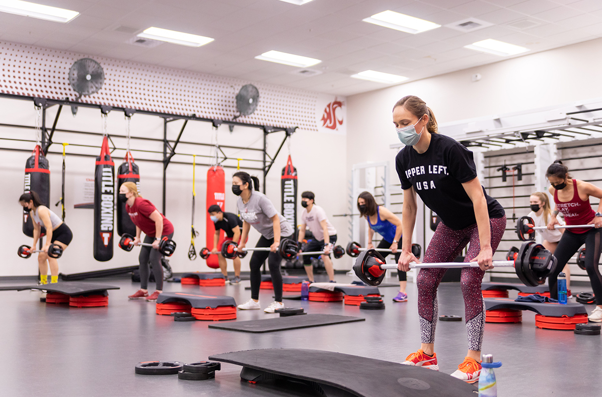 Several people lifting weights during a fitness class.