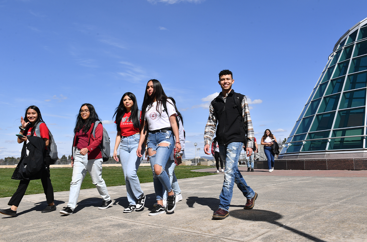 Students smiling as they walk across the WSU Pullman campus.