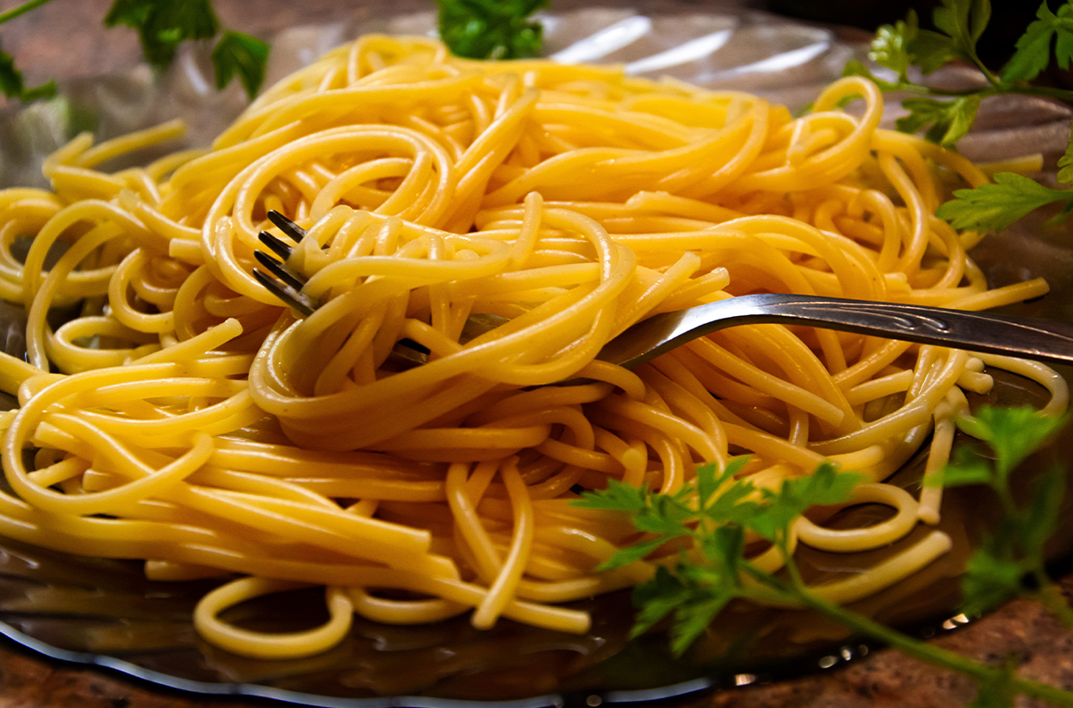 Closeup of a plate of spaghetti noodles and a fork.