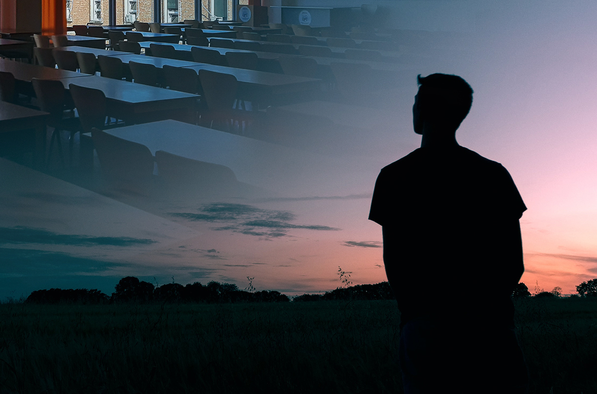 A young adult standing alone in a field looking at the sky. An empty classroom is superimposed in the clouds.