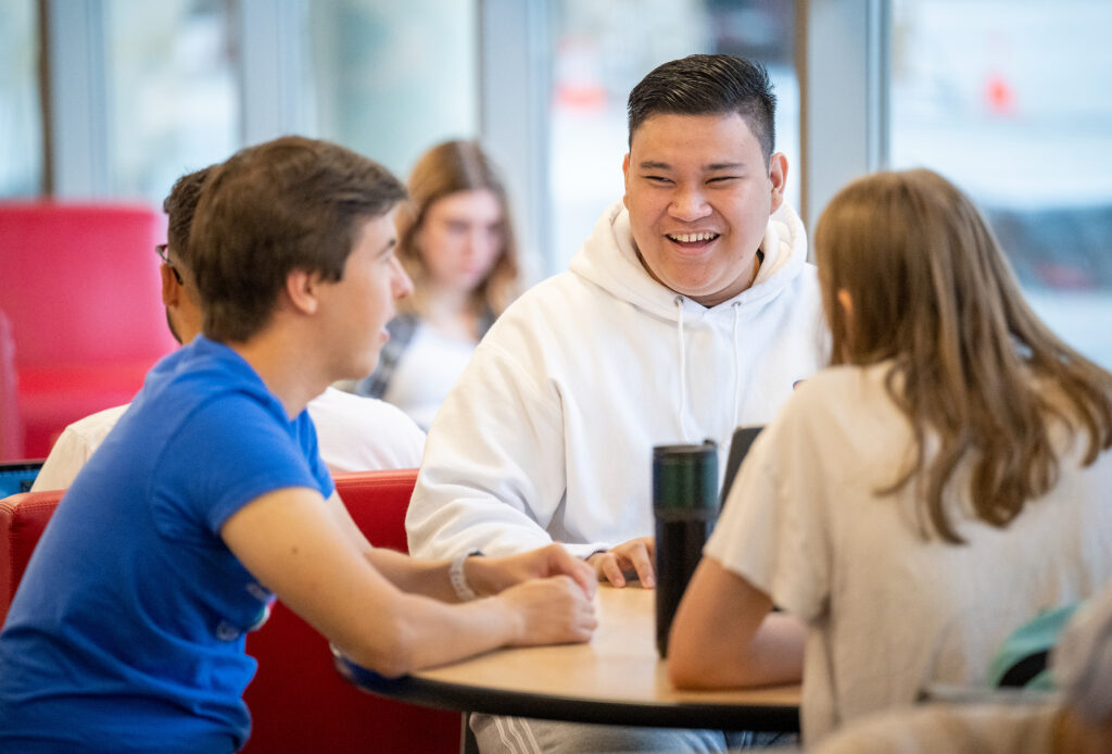 Three WSU Pullman students sitting at a table.