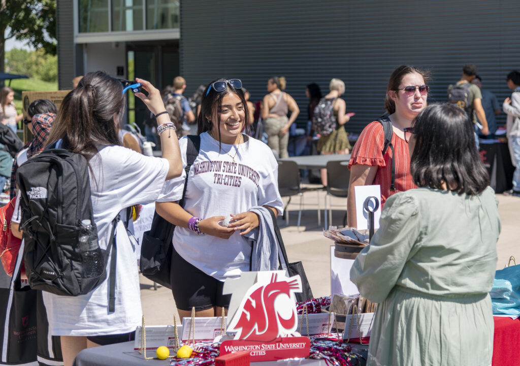 People visiting at an information booth on the WSU Tri-Cities campus.