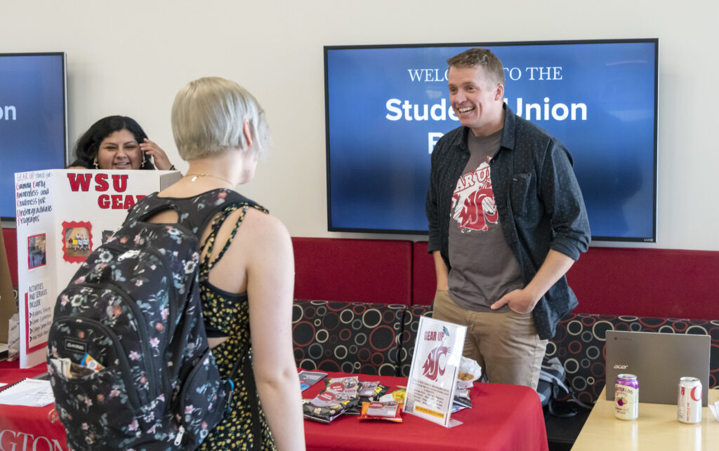 People visiting at an information booth on the WSU Tri-Cities campus.