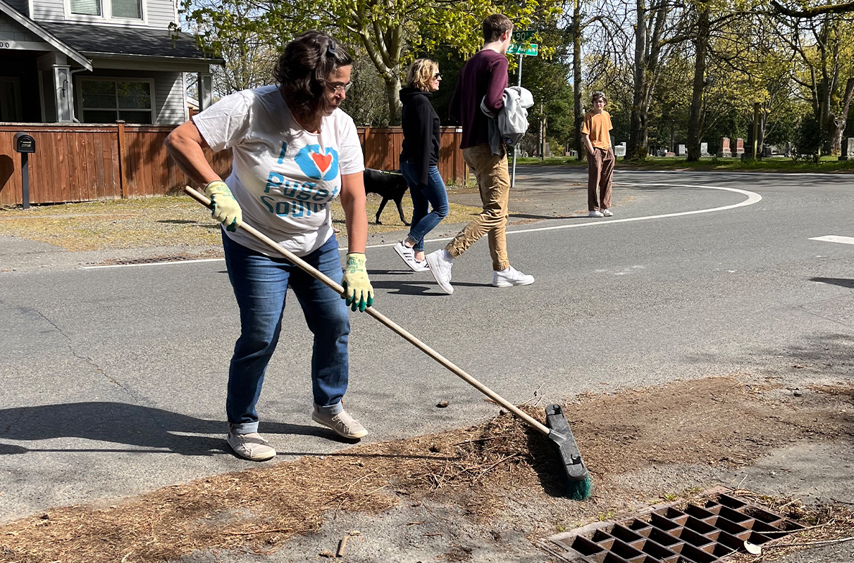 Closeup of Susan Harper cleaning an outdoor drain.